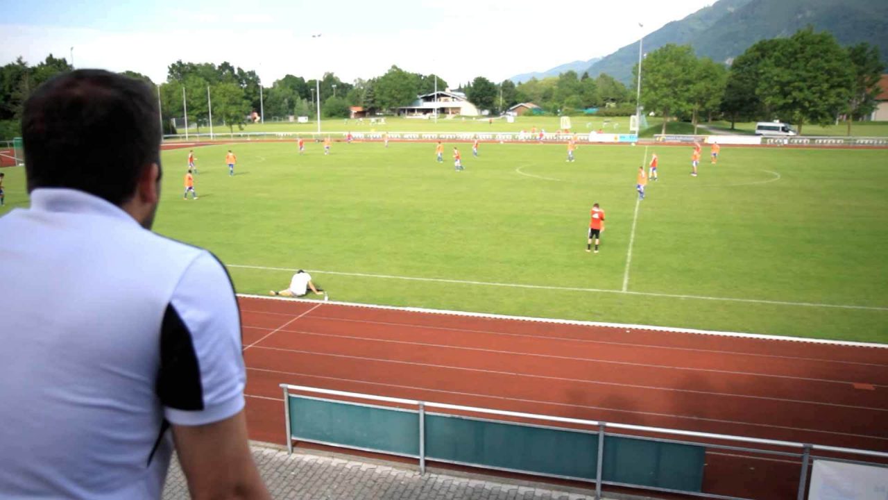 Trainer schaut auf Spielfeld Trainer schaut auf Spielfeld