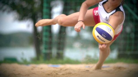 Frau beim Beachvolleyball Sprungbereit: Beim Beachvolleyball liegt man(n) oder frau schonmal waagerecht in der Luft.
