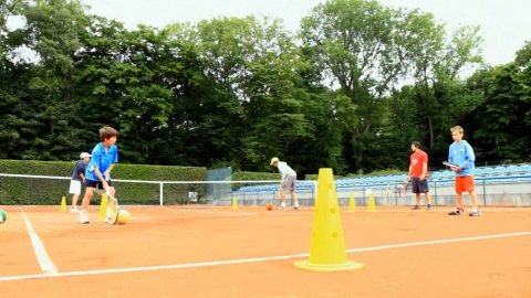 Kinder beim Tennistraining mit Ball am Boden Der Ball rollt: Ganz zu Beginn sollten die Kinder den Tennisball noch nicht springend erleben.