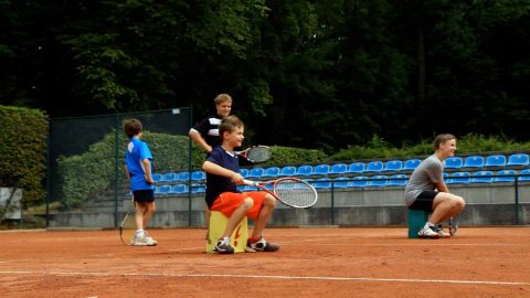 Tennis Übung im Sitzen Willkommene Sitzgelegenheit: Dem Trainer bieten sich diverse Möglichkeiten, um den Kindern das Spielen zu erleichtern.