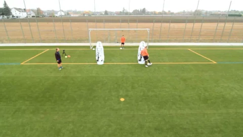 Zunächst wird der Ball so schnell wie möglich um die beiden Dummies herumgespielt. Zunächst wird der Ball so schnell wie möglich um die beiden Dummies herumgespielt.